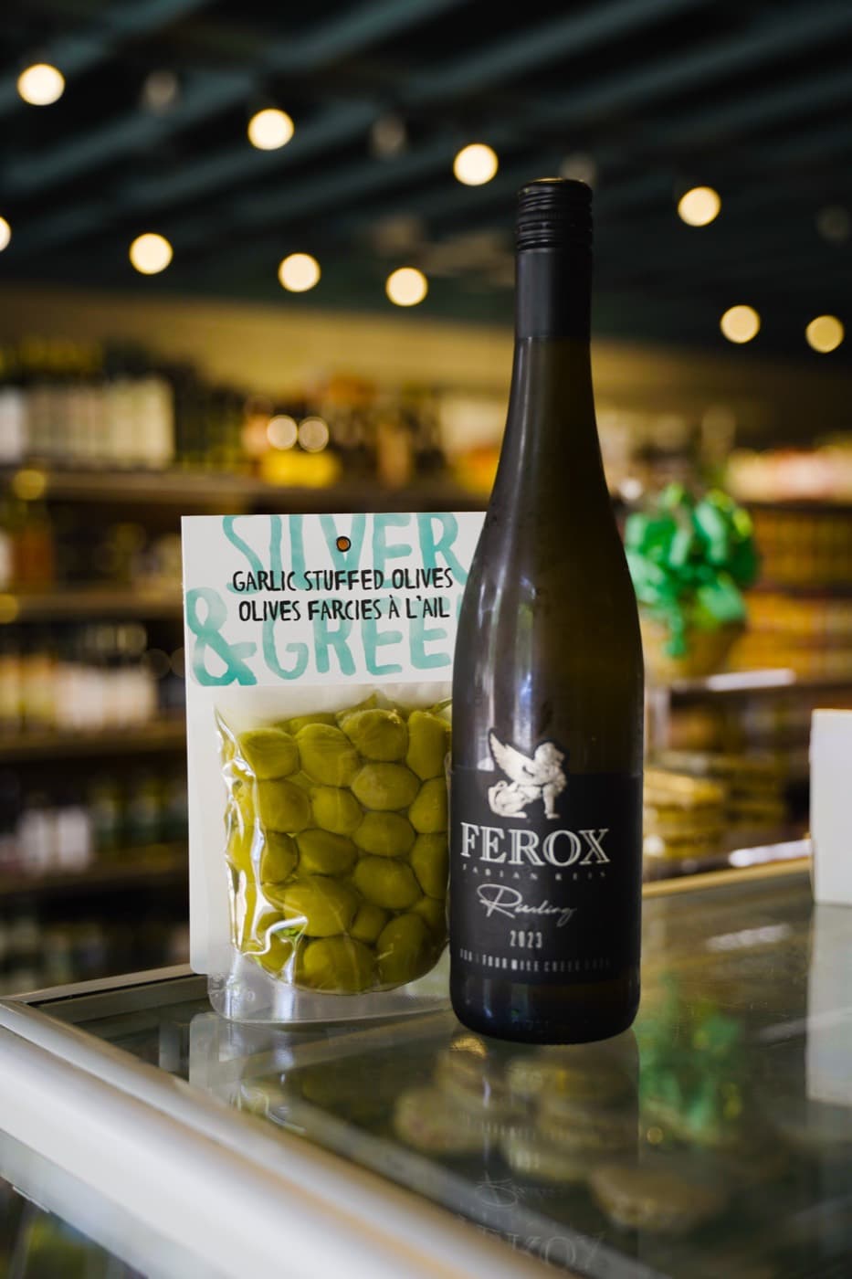 Social post: Ferox Riesling paired with garlic-stuffed olives on the shop counter.