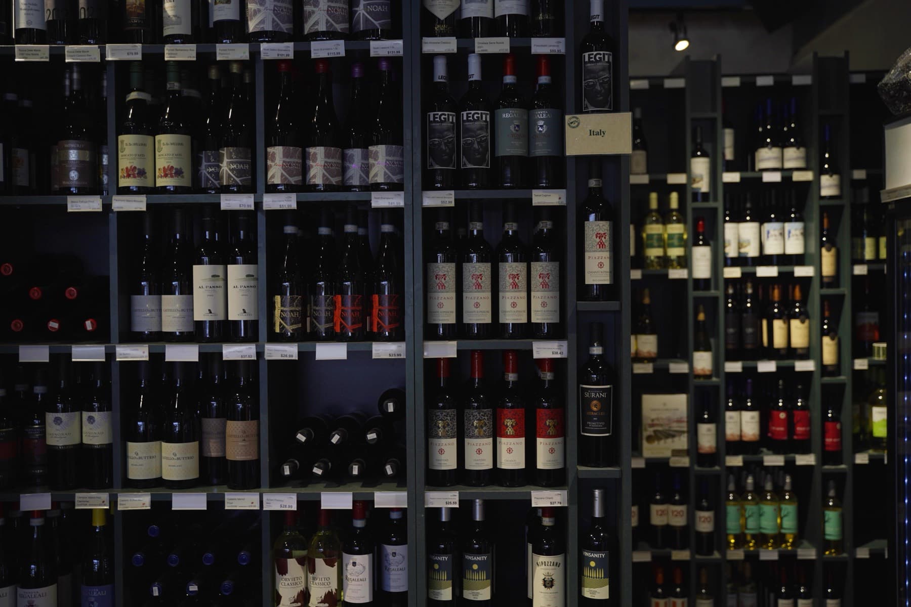 The lit Italian wine wall inside the shop.